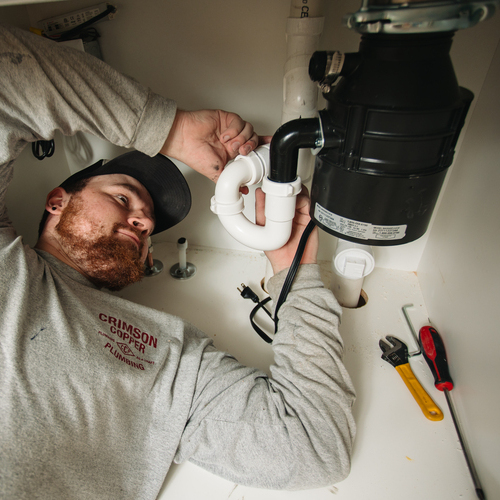 plumber working on a garbage disposal