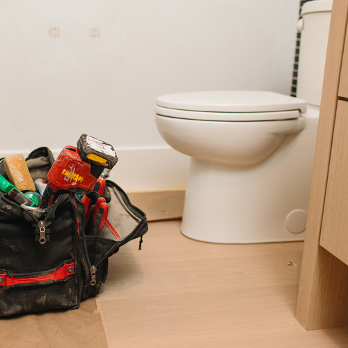 repairs being done on a toilet
